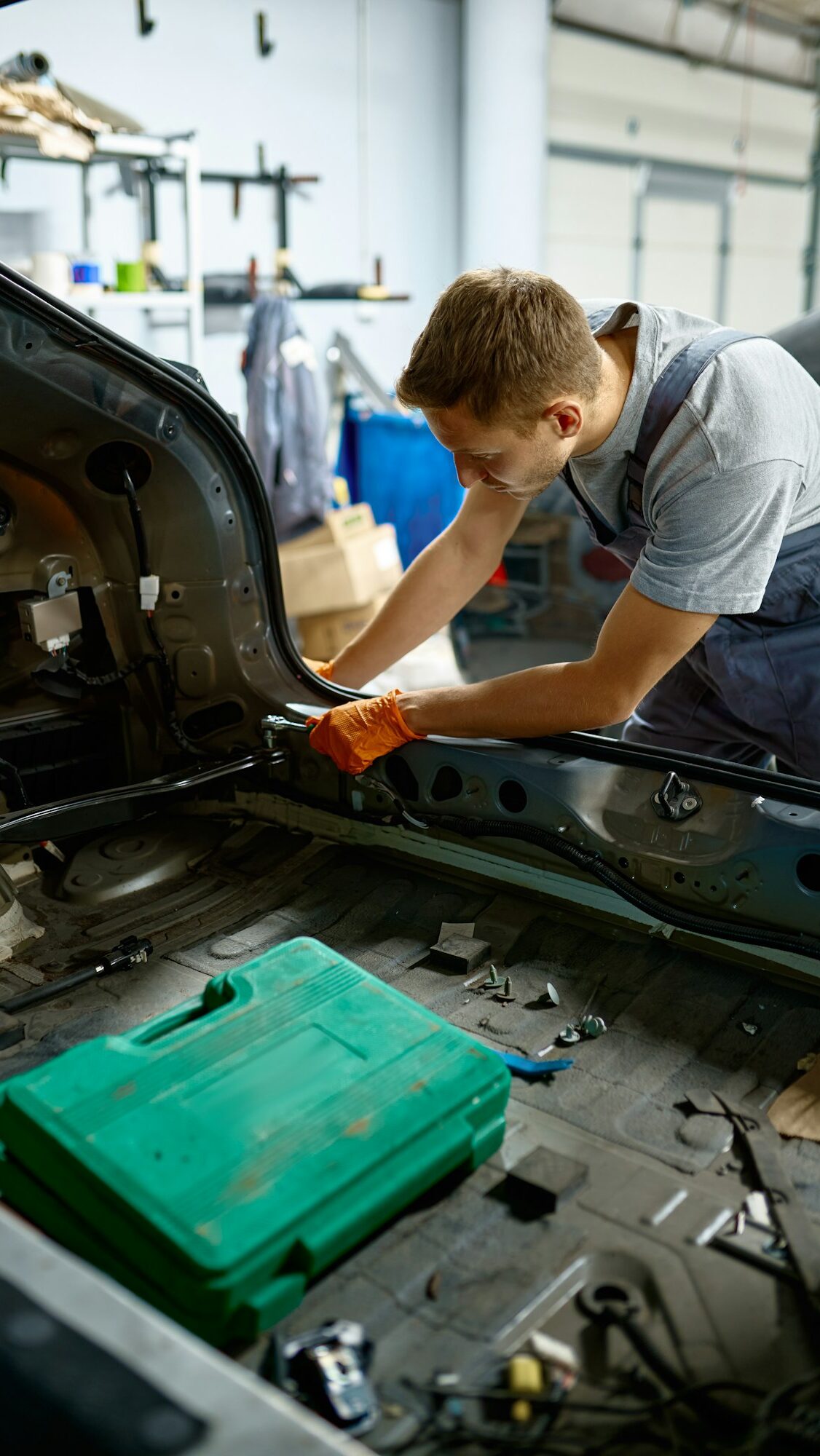 Workman fixing bolt during car body repair